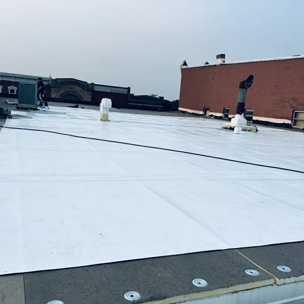 Roofer hot-air welding PVC seams on Mason City Iowa commercial roof
